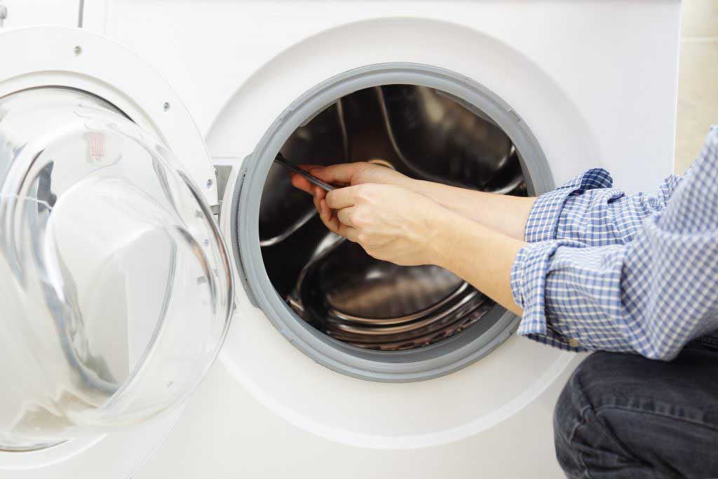 A technician replacing interior part of washing machine