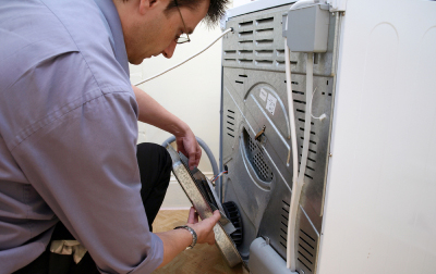 A man repairing a dryer